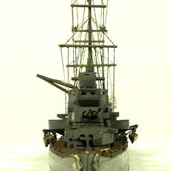Naval ship with two masts, front view.
