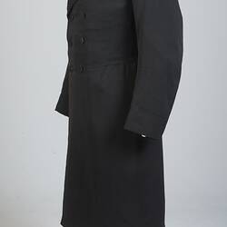 Gentleman's black cotton frock coat, six-button, double-breasted with peaked lapels.