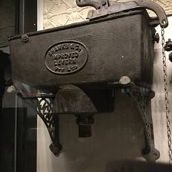 Black cast irn rectangular cistern with raised lettering in centre. Pull chain at right.