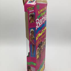 Side of Barbie box. Pink with colourful stripes and images of Barbie dolls.