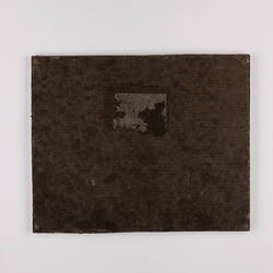 Plain back of a brown exhibition label.