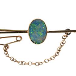 Gold bar brooch with central oval opal. Fine saftey chain attached at left.