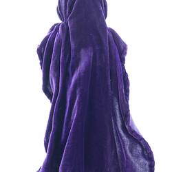 A doll dressed as an abbess in long purple robes
