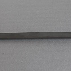 Metal pendulum lying flat.