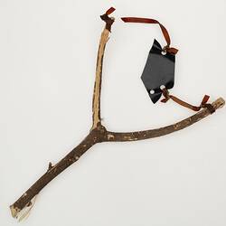 Slingshot made from a forked tree branch with a rubber band.