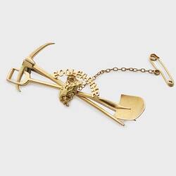 Gold miners brooch with pick and shovel motif.