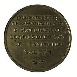 Round brass medal with raised text.