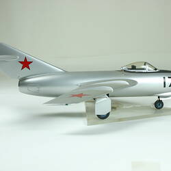 Silver aeroplane model with red star decoration.