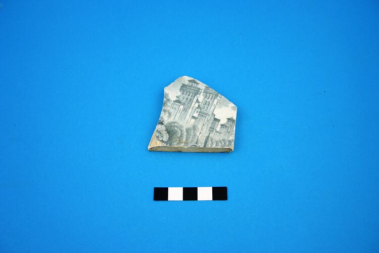 Ceramic shard with illustration of buildings.
