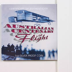 Leaflet cover with printed image of blue biplane flying above crowd. Red and white printed text.