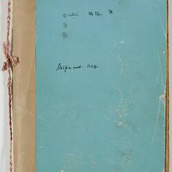 Worn pale blue notbook with handwritten text on front. String along spine.