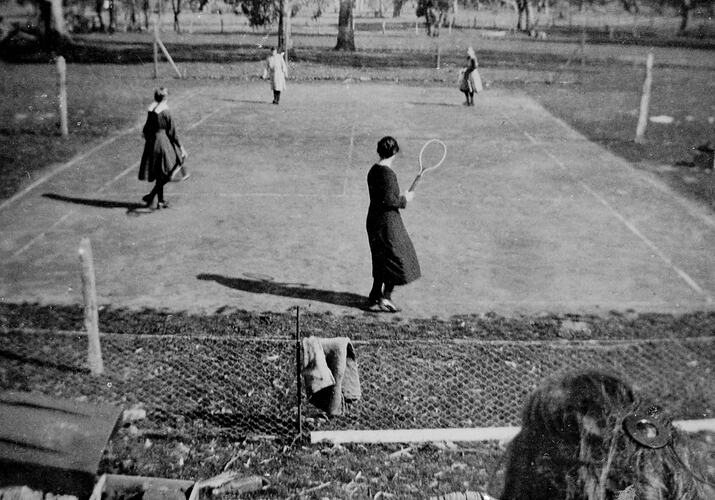 Four girls playing tennis.