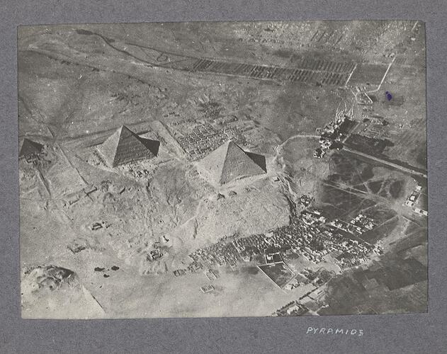 Aerial view of three pyramids, with nearby settlement in lower right.