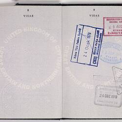 Open passport with white pages and black printed text. Blue handwriting. Stamped.