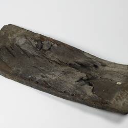 Rectangular warped piece of wooden ship plank.