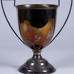 Tarnished silver trophy cup with handles.