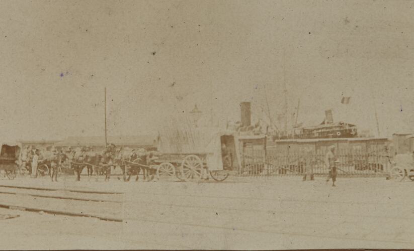 Faint image of four horse-drawn ambulance. Behind it a berthed French transport ship.