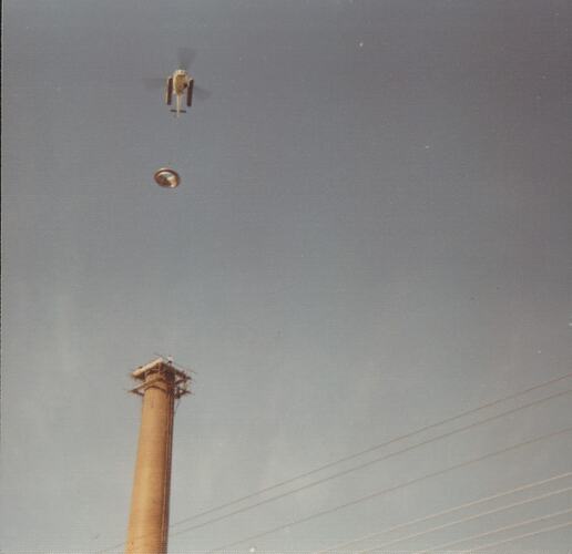 Helicopter flying with chimney lid above chimney.