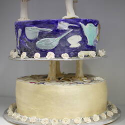 Side of lower two tiers of ceramic wedding cake.