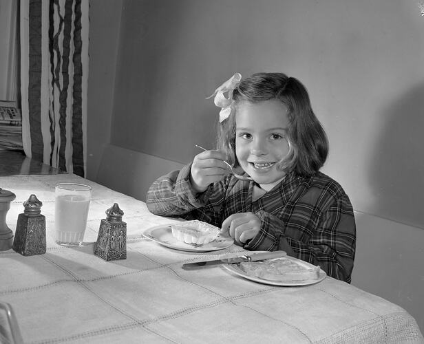 Girl Eating a Boiled Egg from Plastic Packaging, Melbourne, Victoria, 1956