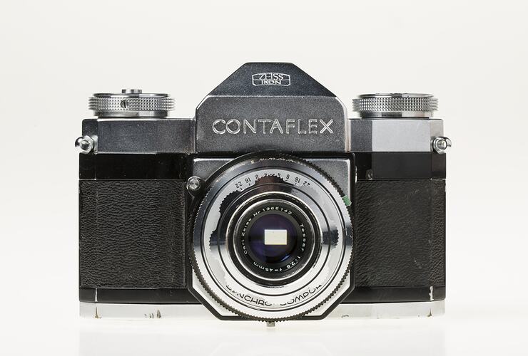 Black camera, central metal lens section and dials on top.