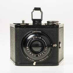 Black cube shaped all metal camera. Carry handle on the top plate.