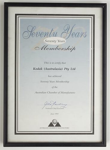White cardboard certificate within black metal frame.