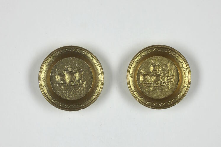 Two toy round gold plates.