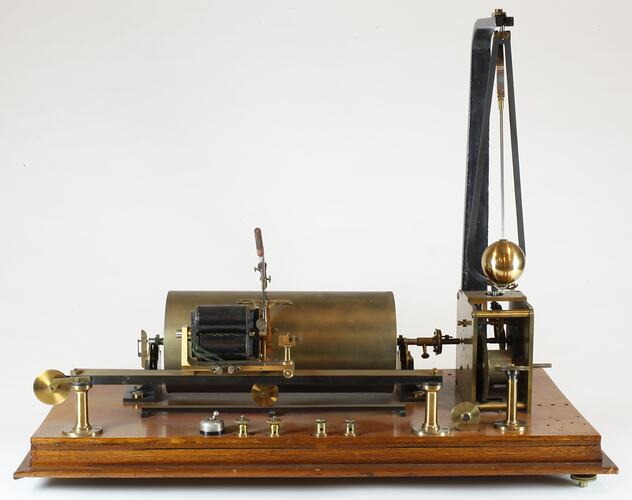 Scientific instrument on wooden base with brass cylinder and sphere.