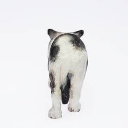 Black and white dog figurine. Back view.