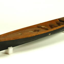 Wooden boat with black hull, three quarter view.
