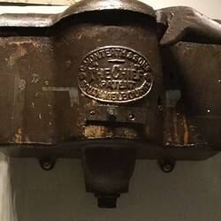 Rectangular black cast iron cistern with raised lettering in centre. Chain pull at right.
