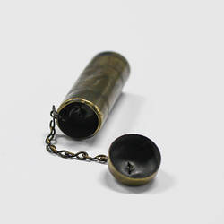 Cylindrical brass tinder box with lid on chain.
