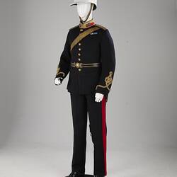 Navy officer's uniform with gold at cuff, epaulettes, belt. Brass buttons. Red/gold collar. White helmet.