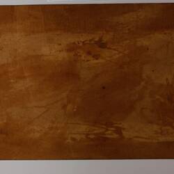 Plain back of a brown exhibition label.
