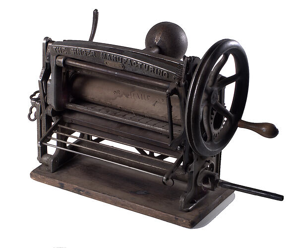 Side view of kilting machine with wooden rollers.