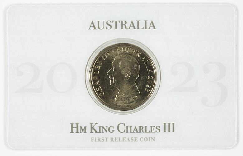 Gold coin depicting King Charles III mounted in rectangular card.