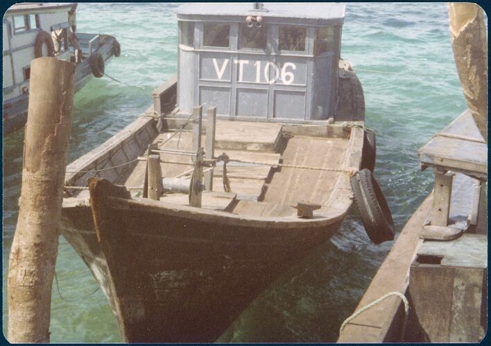 Wooden refugee boat 'VT106', moored at pier.
