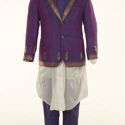 Purple sari two-piece suit and matching tie, long off-white shirt. Gold detail on jacket edging.
