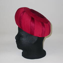 Red organza turban style hat on head model.