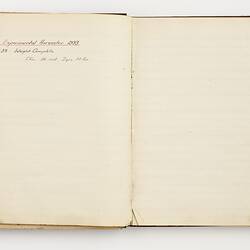 Open book with off white ruled pages. Handwritten text.