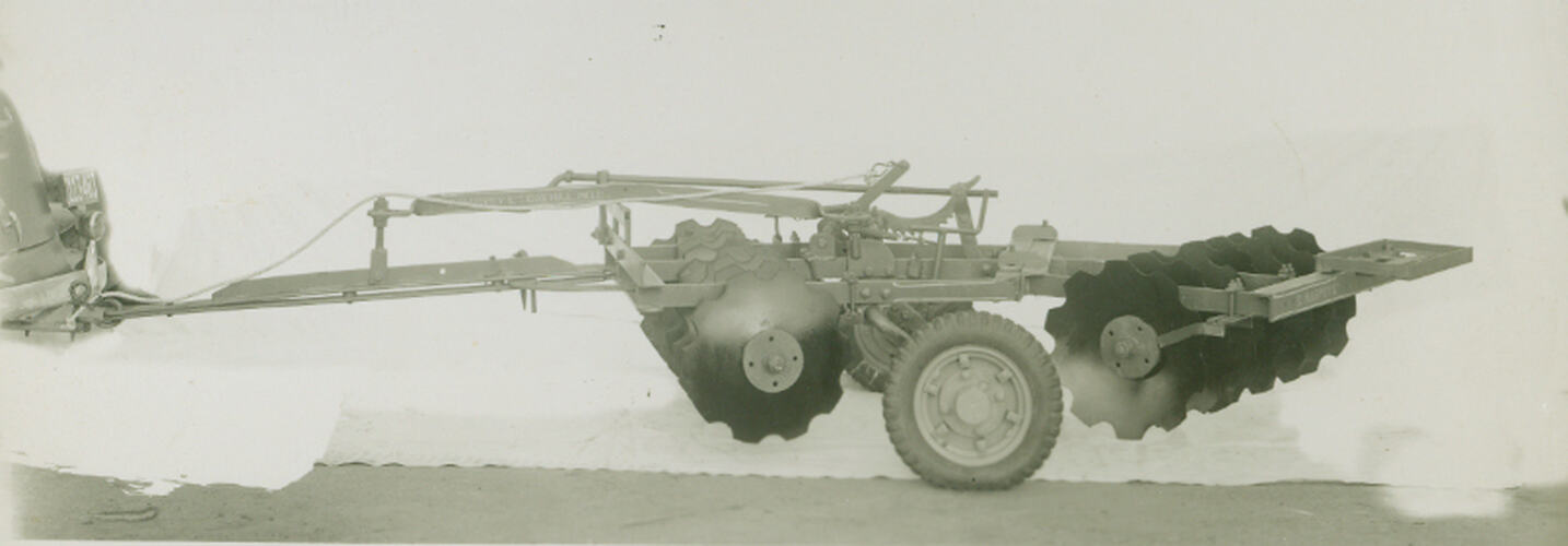 Photograph - Car towing a double-disc harrow