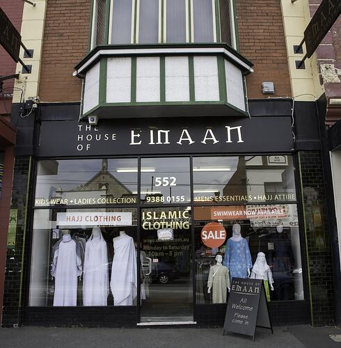 Shop front, black building with large glass windows and doors. Golden lettering above.