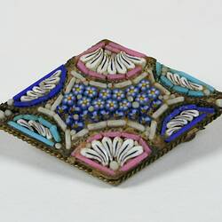 Diamond shaped broach with blue, pink and white beads.