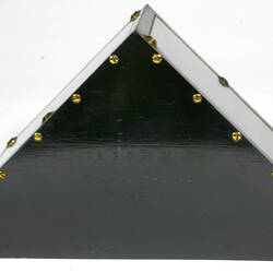 Pyramid shaped black metal instrument, triangular end showing.
