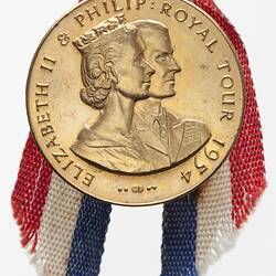 Medal with conjoined right facing profile of Queen Elizabeth and Prince Phillip. Red, white blue ribbon.