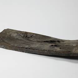 Rectangular warped piece of wooden ship plank.