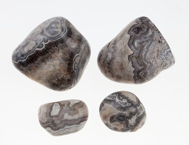 Four black and white patterned agate pebbles.