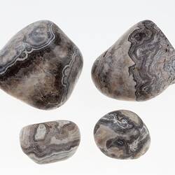 Four black and white patterned agate pebbles.