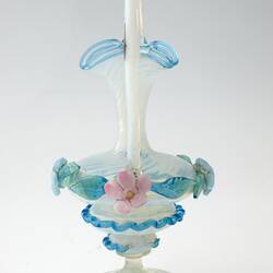 Blue blown-glass ewer, spiral fluted neck, serpentine handle, flattened bulbous body layered with pink, blue, green flowers and leaves.